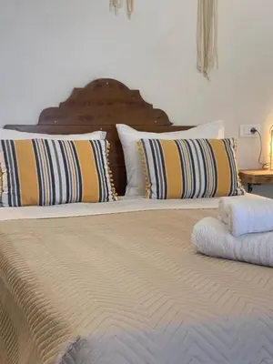 a bed with two pillows on top of it at ALEMINAS House 1 in Symi