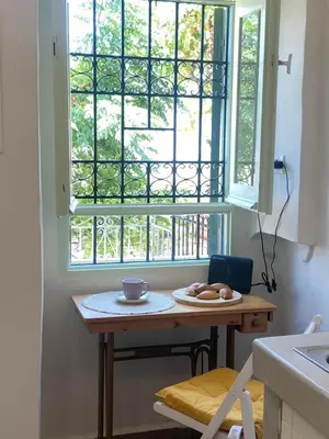 a kitchen with a table and a window with food on it at ALEMINAS House 1 in Symi
