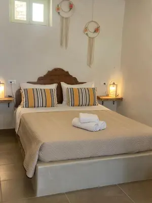 a bedroom with a large bed with two towels on it at ALEMINAS House 1 in Symi
