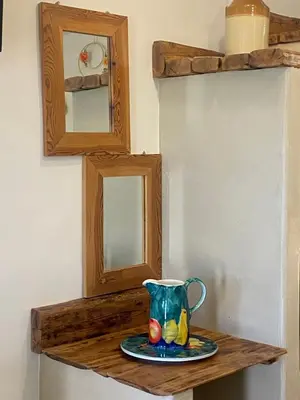 a vase sitting on a wooden shelf with a plate at ALEMINAS House 1 in Symi