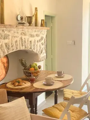 a dining room table with a bowl of fruit on it at ALEMINAS House 1 in Symi
