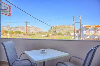 a table and chairs with a view of mountains from a window at Davinci's Studios in Haraki