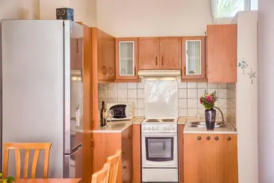 a kitchen with wooden cabinets and a white refrigerator at Davinci's Studios in Haraki