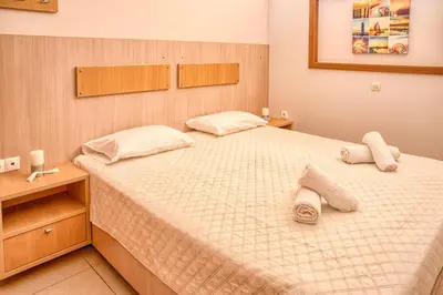 a bedroom with a large bed with towels on it at Davinci's Studios in Haraki