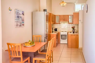 a kitchen with a table and chairs and a refrigerator at Davinci's Studios in Haraki