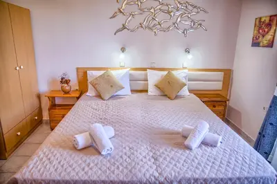 a bedroom with a large bed with towels on it at Davinci's Studios in Haraki