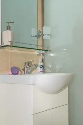 a bathroom sink with a glass mirror above it at House of Helios in Pastida