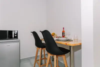 a kitchen with a wooden table and two black chairs at House of Helios in Pastida