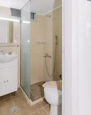 a bathroom with a shower and a toilet and a sink at House of Helios in Pastida