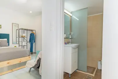 a bedroom with a bed and a bathroom with a sink at House of Helios in Pastida