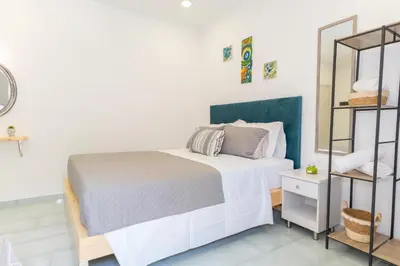 a white bedroom with a bed and a shelf at House of Helios in Pastida