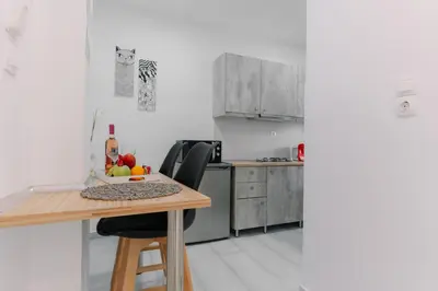 a small kitchen with a wooden table and chairs at House of Helios in Pastida