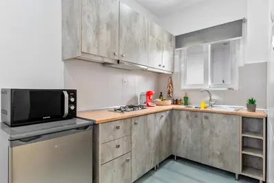 a kitchen with wooden cabinets and a microwave at House of Helios in Pastida