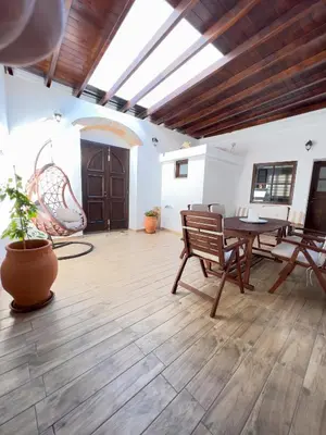 a large room with a wooden floor and a table and chairs at Villa AleNi Lindos in Líndos