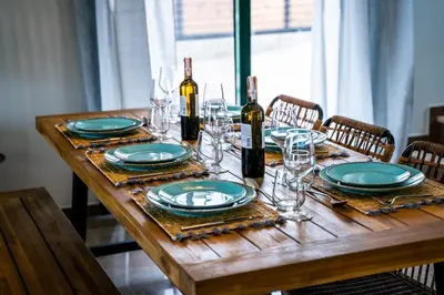 a wooden table with plates and glasses and wine bottles at Heliophos Villa Aelia in Kiotari