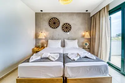 two twin beds in a room with a window at Heliophos Villa Aelia in Kiotari