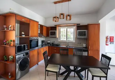 a kitchen with a table and a dining room at Villa Emerald in Asgourou