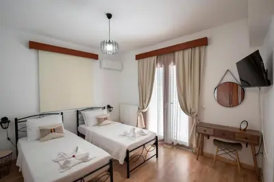 a bedroom with two beds and a tv and a television at Villa Emerald in Asgourou