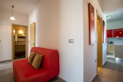 a red couch in a room with a kitchen at High View Villa in Afantou