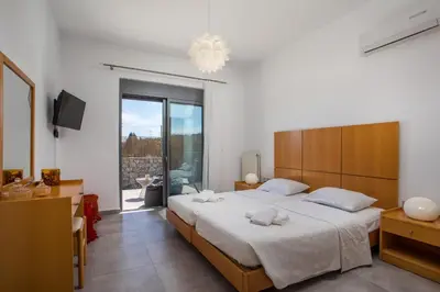 a bedroom with a large bed and a large window at High View Villa in Afantou