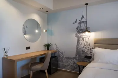 a bedroom with a desk with a lighthouse mural on the wall at Prasonisi Lighthouse Boutique Hotel in Prasonisi
