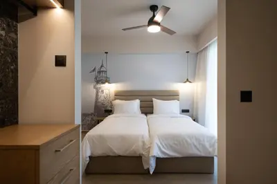 a bedroom with a bed with white sheets and a ceiling fan at Prasonisi Lighthouse Boutique Hotel in Prasonisi