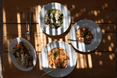 four plates of food on a wooden table at Prasonisi Lighthouse Boutique Hotel in Prasonisi