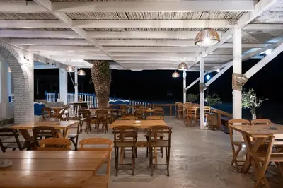 a restaurant with wooden tables and chairs and lights at Prasonisi Lighthouse Boutique Hotel in Prasonisi