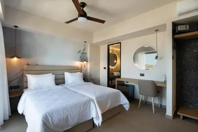 a bedroom with a bed and a desk and a mirror at Prasonisi Lighthouse Boutique Hotel in Prasonisi