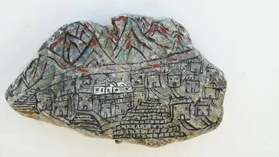 a rock with a painting of a city on it at Pavlos Rooms in Livadia