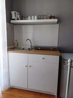 a kitchen with white cabinets and a sink at ZEUS Studios in Rhodes Town