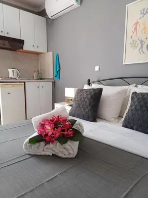 a bedroom with a couch with a bouquet of flowers on it at ZEUS Studios in Rhodes Town
