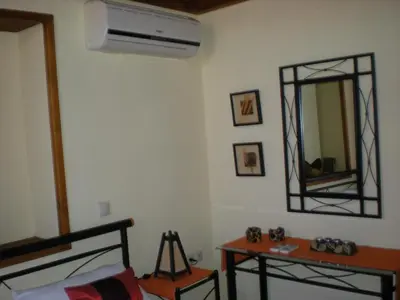 a room with a mirror and a bed and a table at Mika's House in Halki