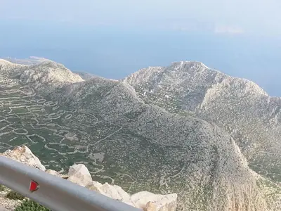 a view of a mountain range with trees and grass at Mika's House in Halki