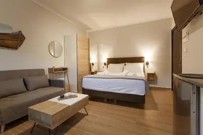 a hotel room with a bed and a couch at Serenity Studio for couples in Rhodes Town