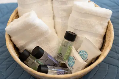 a basket filled with toiletries and towels on a bed at Mosaic Luxury Home in Rhodes Town