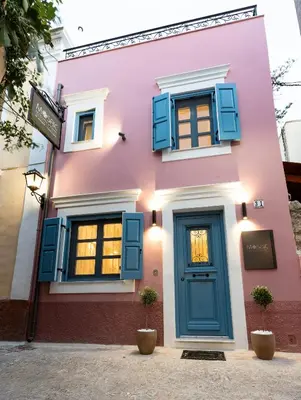 a pink house with blue windows and a door at Mosaic Luxury Home in Rhodes Town