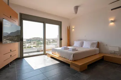 a bedroom with a large bed and a large window at Villa Katerina in Líndos