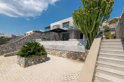 a house with stairs and a palm tree in front of it at Villa Katerina in Líndos
