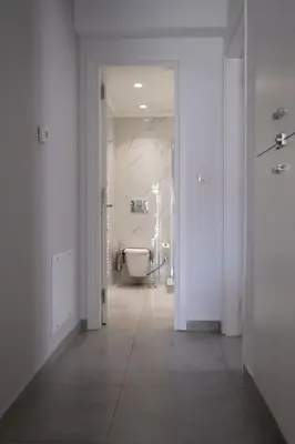 a white bathroom with a toilet and a tub at Luxury spacious apartment in the heart of the city in Rhodes Town