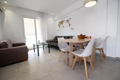 a living room with a table and chairs and a couch at Luxury spacious apartment in the heart of the city in Rhodes Town