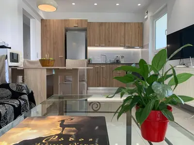 a living room with a glass table and a kitchen at Luxury spacious apartment in the heart of the city in Rhodes Town