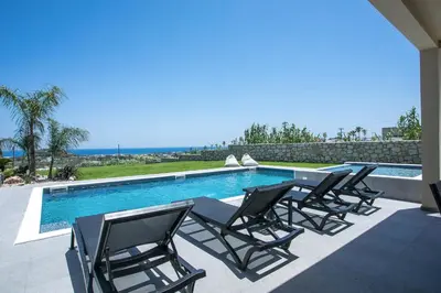 a group of chairs sitting next to a swimming pool at Madi Villa in Faliraki