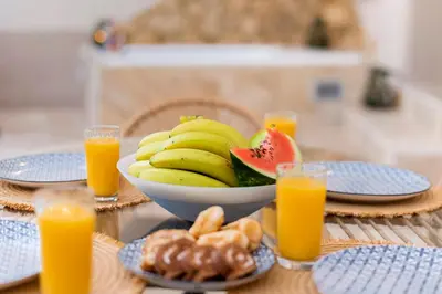 a table with a bowl of bananas and a bowl of orange juice at ALMI Traditional House in Koskinou