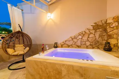 a large tub in a room with a rock wall at ALMI Traditional House in Koskinou