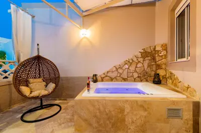 a bath tub in a room with a chair at ALMI Traditional House in Koskinou