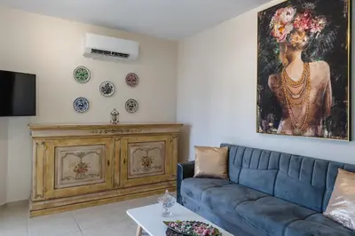 a living room with a blue couch and a painting on the wall at namaste in Rhodes Town