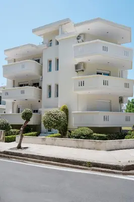 a white apartment building with trees in front of it at namaste in Rhodes Town