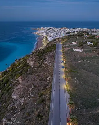 an aerial view of a road on a hill next to the ocean at namaste in Rhodes Town