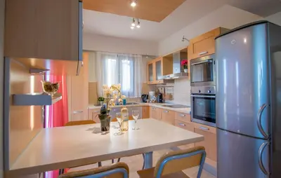 a kitchen with a table and a stainless steel refrigerator at Haraki Villas in Haraki